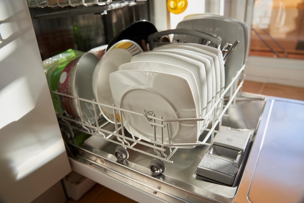 Photo side view of dishes and utensils in a dishwasher