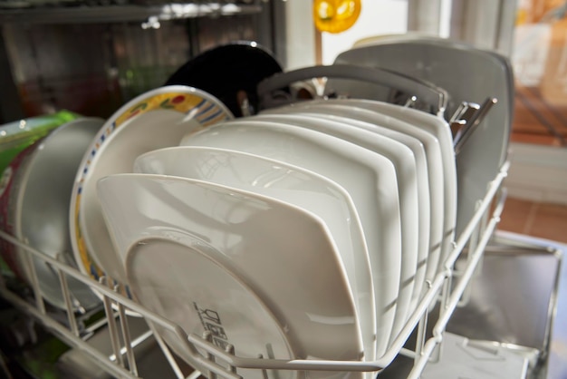 Photo side view of dishes and utensils in a dishwasher