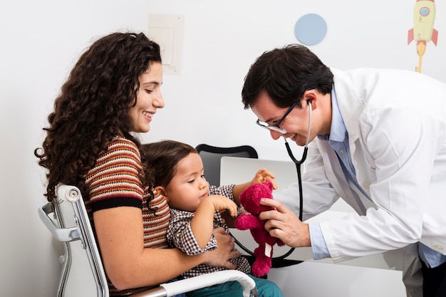 Photo side view doctor checking baby boy