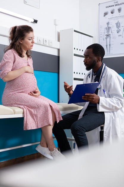 Photo side view of doctor examining patient in hospital