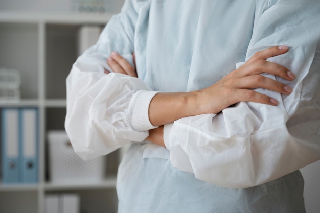 Medico di vista laterale in piedi con le braccia incrociate