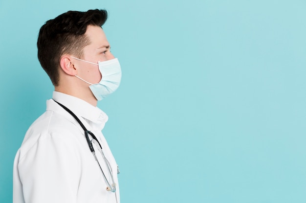 Photo side view of doctor with medical mask and stethoscope