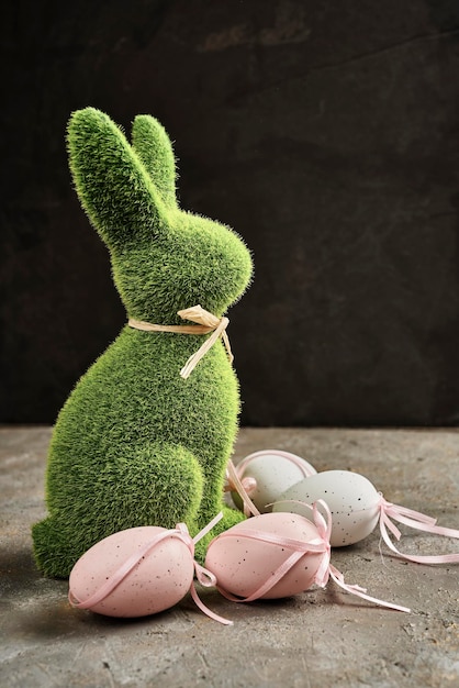 아름다운 부활절 달걀이 있는 잔디로 만든 부활절 토끼 동상의 측면 보기
