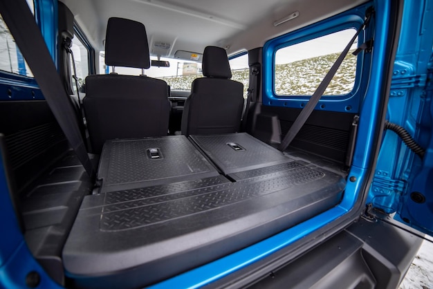 Photo side view of empty open car trunk with seats folded into flat flor of suv crossover open trunk door