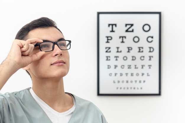 Photo side view of eye specialist trying on pair of glasses