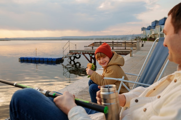 Photo side view family hanging out on a jetty