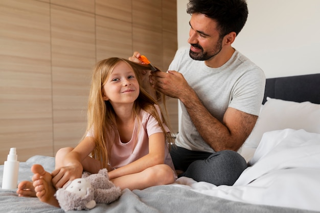 Photo side view father using lice comb