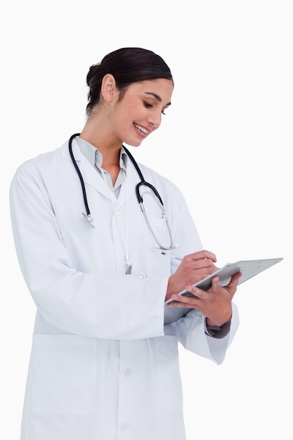 Side view of female doctor taking notes against a white background