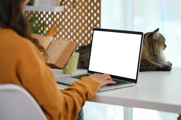 Photo side view of female freelancer working online at home on laptop blank screen for text