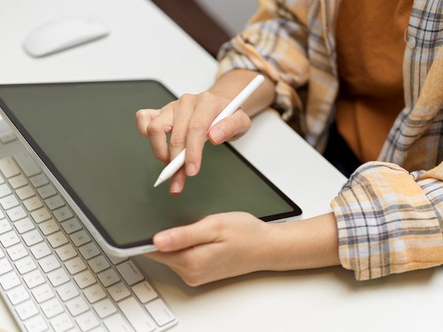 Side view of female freelancer working with digital tablet at home office