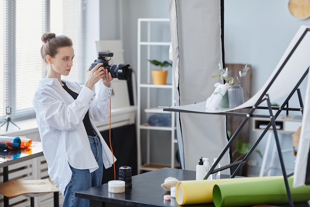 Side View Of Female Photographer Working In Studio