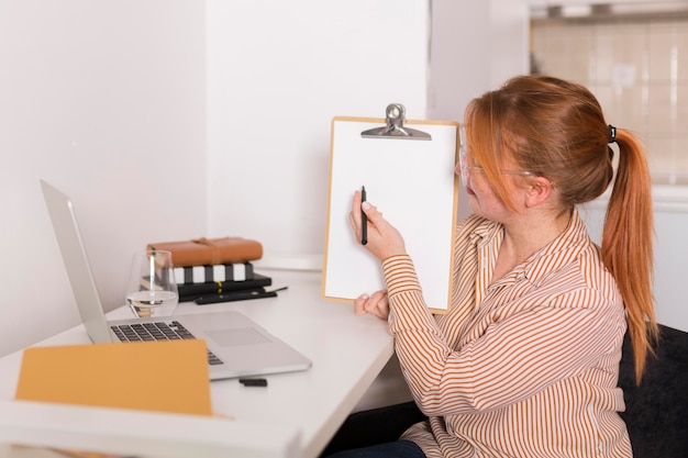 Side view of female teacher showing online class the lesson