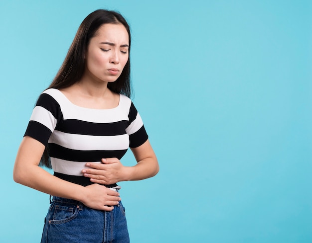 Vista laterale femminile con forte mal di stomaco