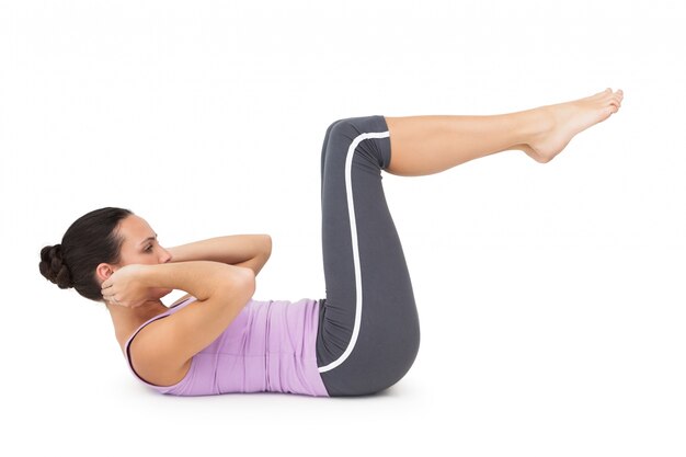 Side view of a fit young woman doing crunches