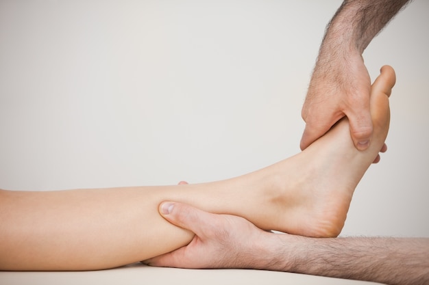 Photo side view of a foot being massaged