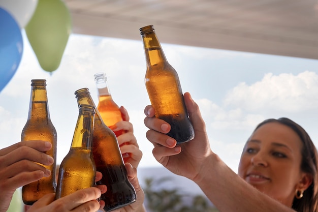 写真 ビール瓶で祝う側面図の友人