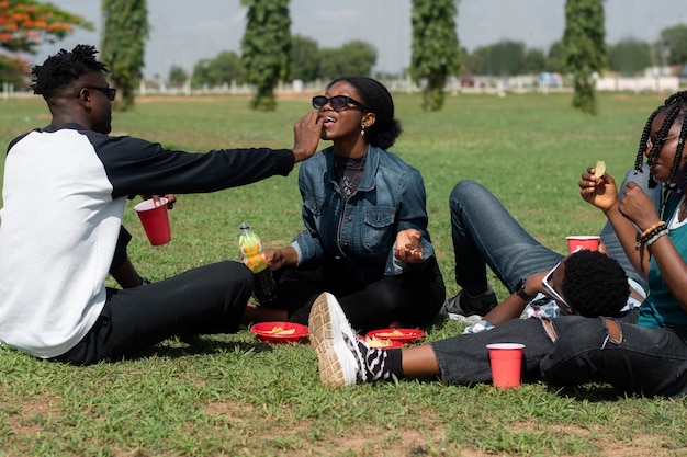 Side view friends sitting on grass