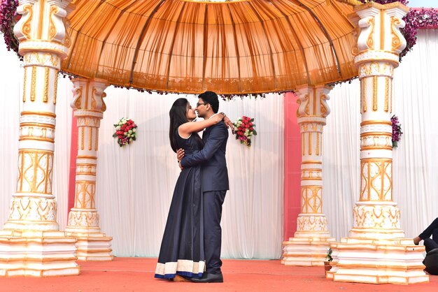 Photo side view full length of bride and bridegroom standing during wedding ceremony