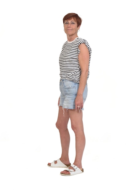 Photo side view of a full portrait of a middle aged woman looking at camera on white background