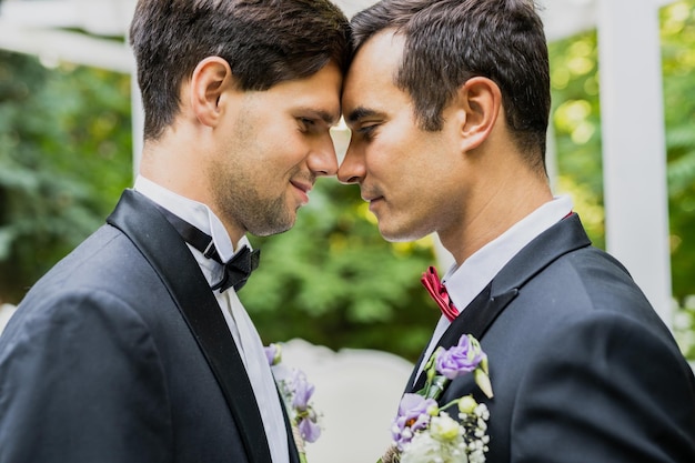 Photo side view of gay couple during wedding ceremony