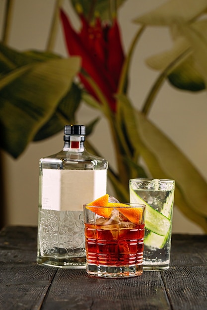 Side view on gin cocktails in glasses with bottle on the wooden table