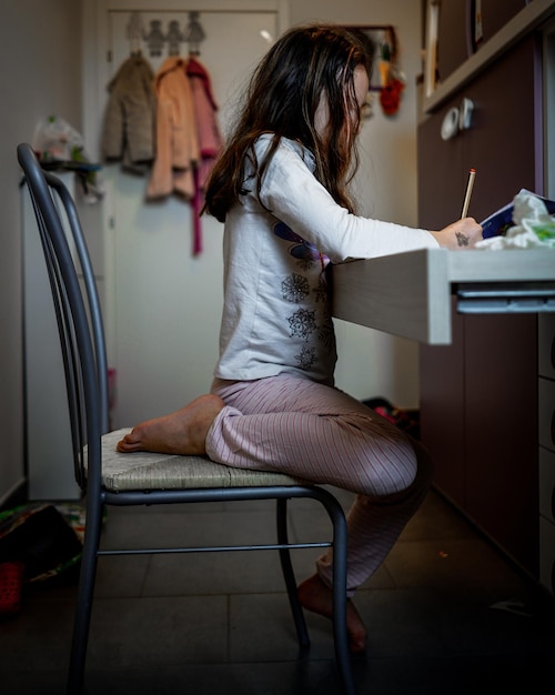 Photo side view of girl doing homework