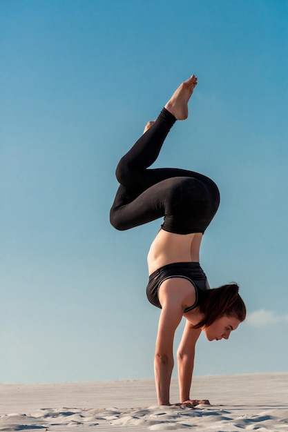 Side view of girl doing squats on grey background