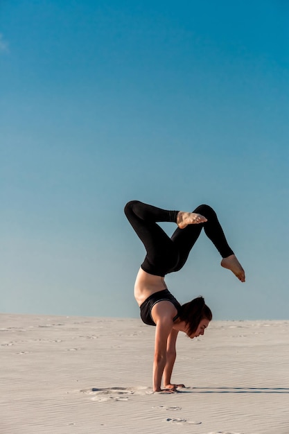 Side view of girl doing squats on grey background