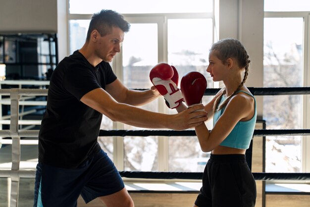 Foto ragazza di vista laterale che impara boxe