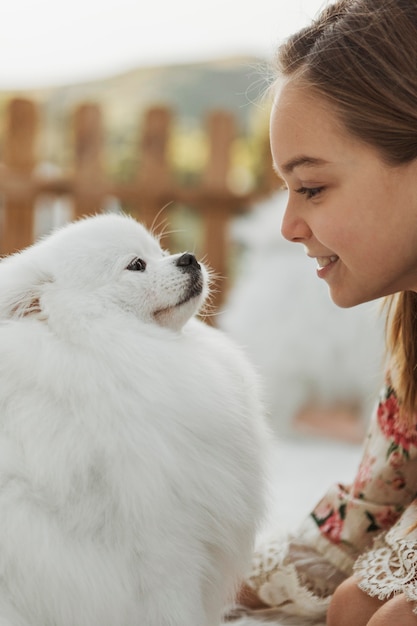 彼女の犬を見ている側面図の女の子