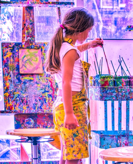 Foto vista laterale di una ragazza che dipinge in uno studio d'arte