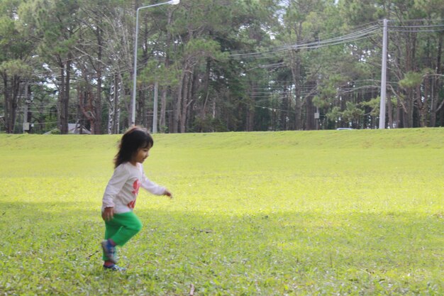 Side view of girl playing on grassy field