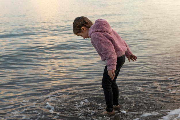 Photo side view girl playing in water