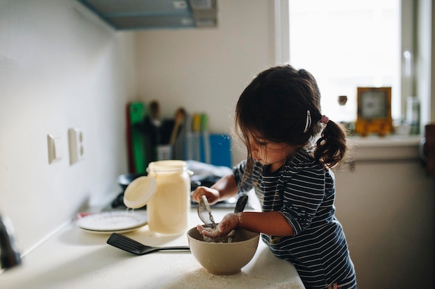 side view of girl preparing food on kitchen counter at home