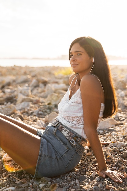 Foto ragazza di vista laterale che si siede all'aperto