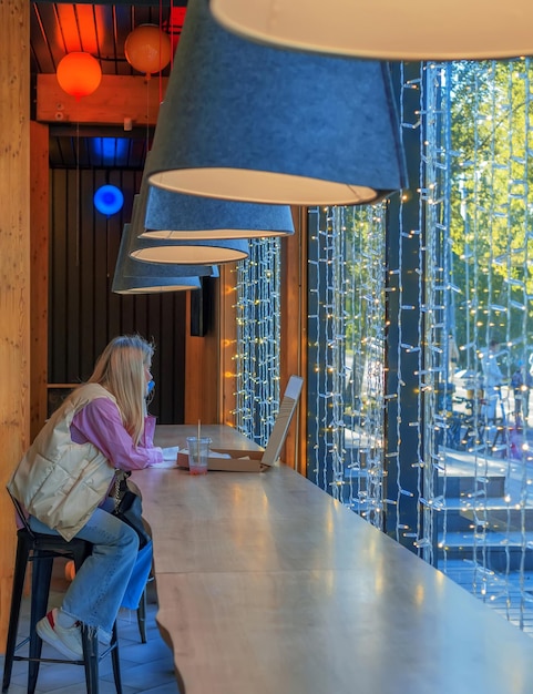 Photo side view of girl sitting on table