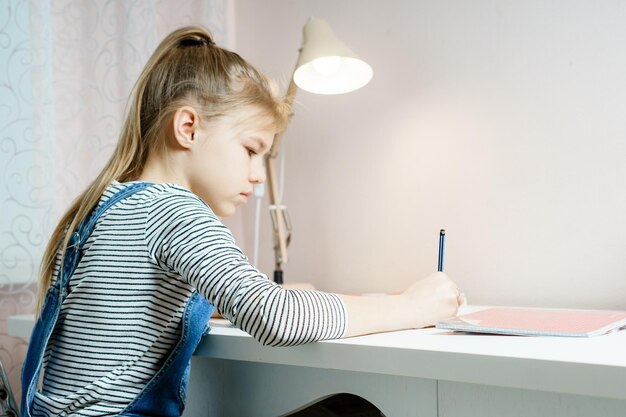 Photo side view of girl sitting on table