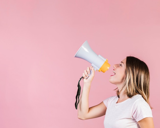 Side view girl speaking on a megaphone