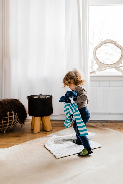 Photo side view of girl standing by window at home