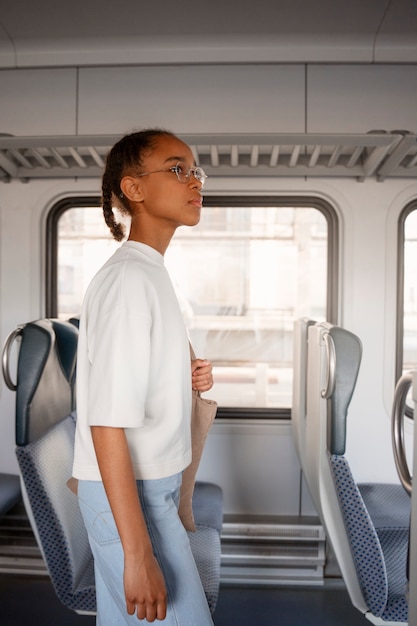 Foto ragazza di vista laterale che viaggia in treno