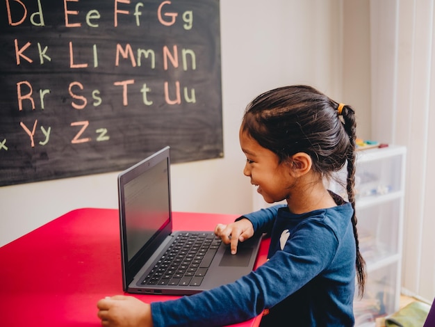 side view of girl using laptop on table