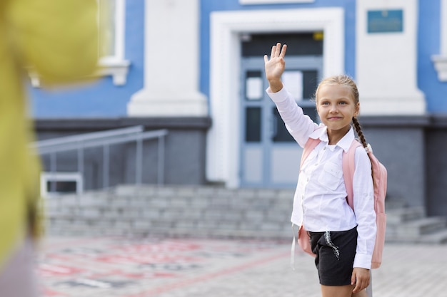 Photo side view girl waving at parent