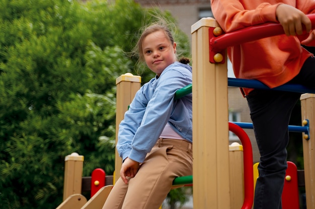 Photo side view girl with down syndrome in park