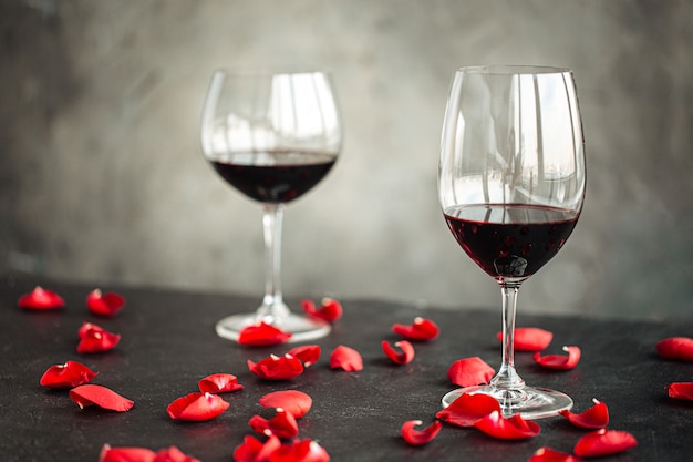 Side view on a glasses of red wine with petals