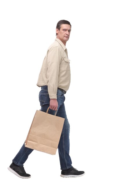Вид сбоку идущего мужчины задумчиво несет сумки с покупками