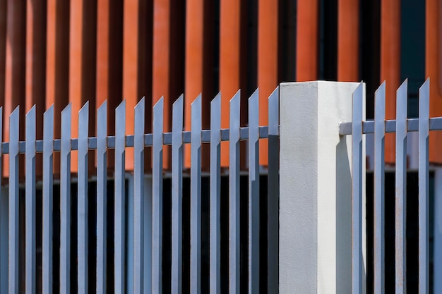 Side view of gray steel fence in sharp designed with blurred\
background of modern office building