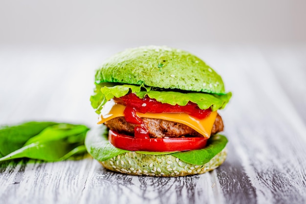 Side view of green burger with artificial meat fresh greenery on wooden table Vegetarian food