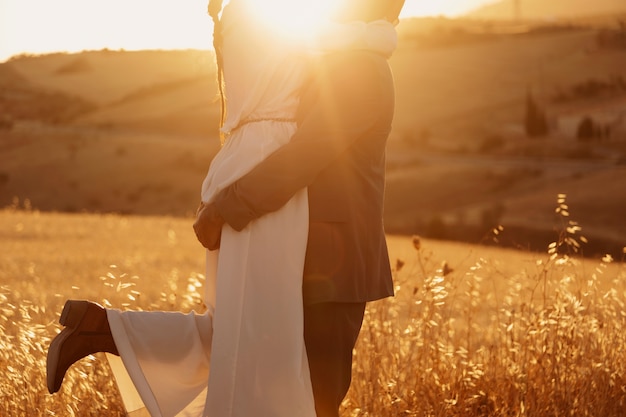 side view groom holding bride