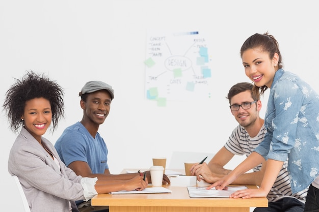 Side view of a group of artists in discussion at desk