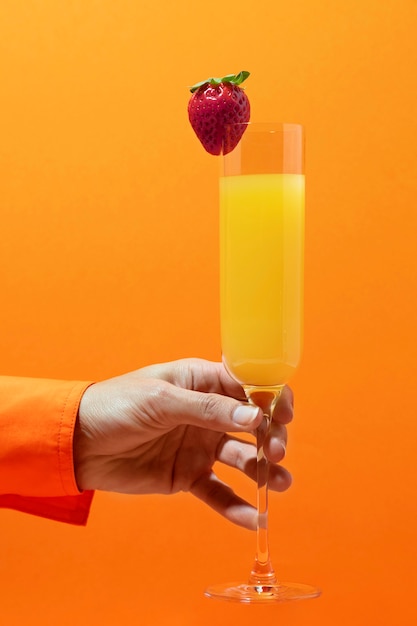 Foto mano di vista laterale che tiene gustoso cocktail di mimosa